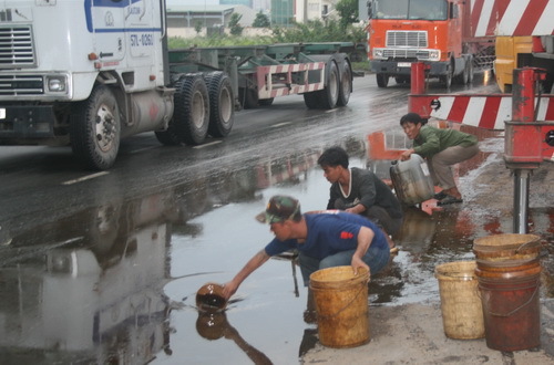 Container lật, dân đổ xô ra đường vớt dầu
