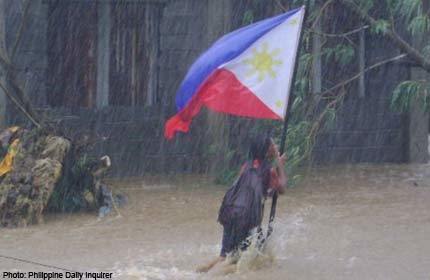 Cảm động cô học trò nhỏ giữ quốc kỳ trong mưa bão