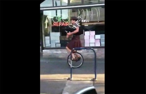 Đi xe đạp 1 bánh thổi kèn trên hè phố