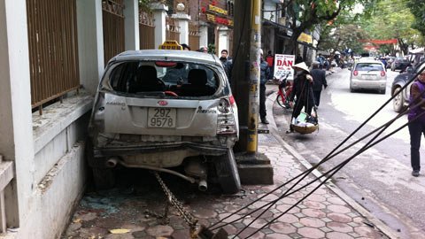 Taxi bị húc kẹp cứng giữa tường và cột điện
