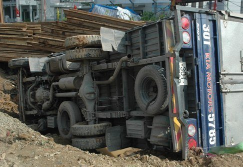 Xe tải mất lái đâm đầu xuống hố công trình