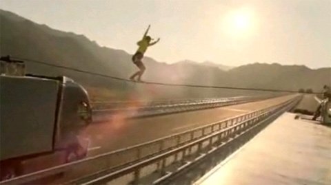 Đi trên dây giữa 2 xe tải đang chạy