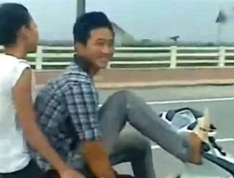 Lái xe máy bằng chân chở bạn gái lao vun vút