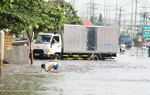 Cởi trần đứng giữa phố ngập nước điều tiết giao thông