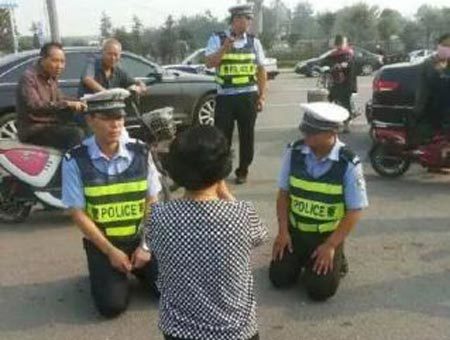 Cảnh sát quỳ xuống đất, giảng luật cho người vi phạm