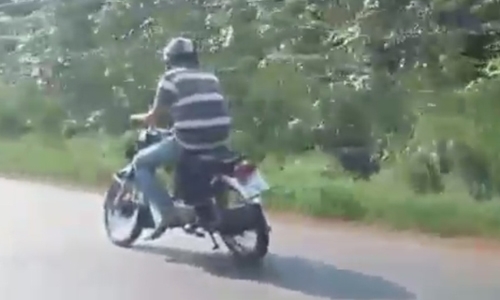Thanh niên đi xe máy lệch hai bánh vẫn bon bon trên đường