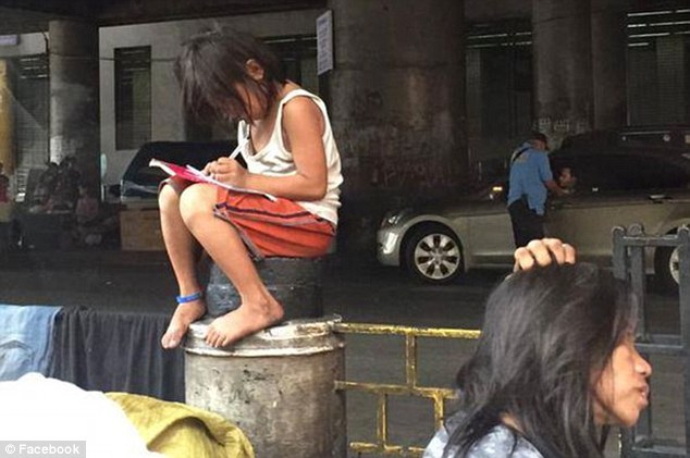 Bé gái ngồi giữa đường học bài làm động lòng trắc ẩn