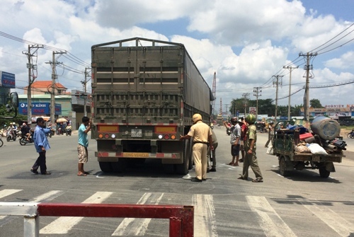 Bé 7 tuổi bị xe container cán nát chân, giao thông hỗn loạn