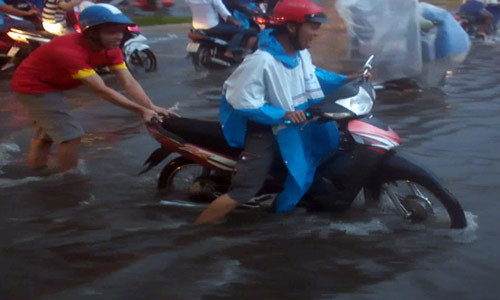 Mưa lớn, người dân Tây Đô đẩy xe về nhà trong nước ngập