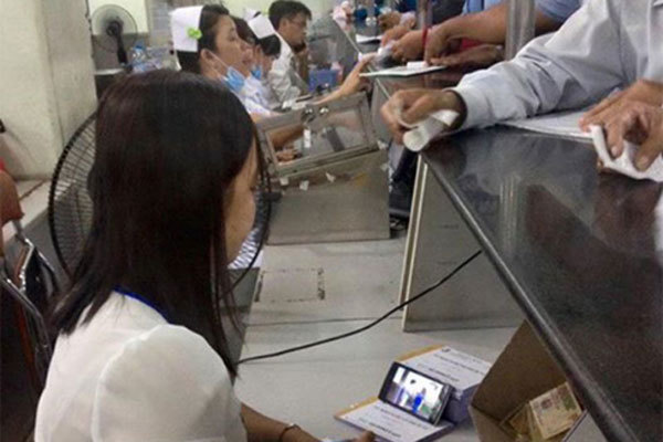 Bức xúc nhân viên vừa thu viện phí vừa xem phim
