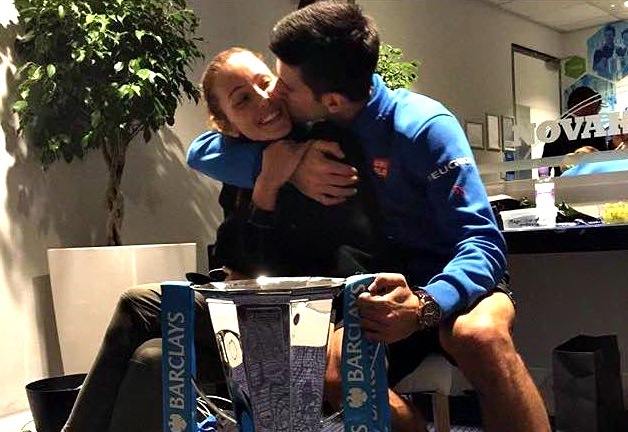 Djokovic một tay cầm cúp, một tay ôm hôn vợ