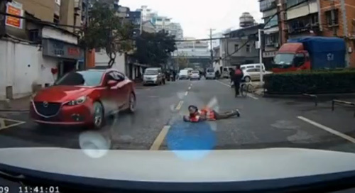 Người phụ nữ nằm ra đường chặn ô tô xin tiền