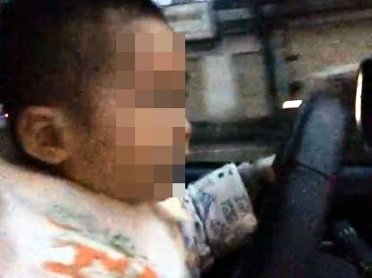 Clip bé trai cầm vô lăng lái xe ô tô giữa phố