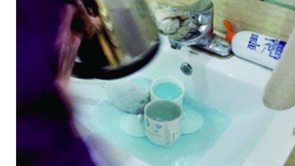 Phục vụ phòng dùng cọ toilet làm sạch cốc cho khách