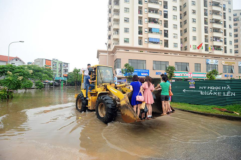 Đu máy xúc đi làm giữa Hà Nội