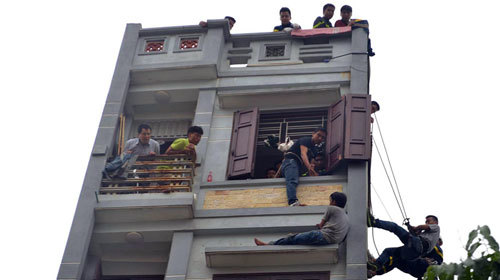 Cảnh sát đu dây cứu thanh niên vật vã trên cửa sổ tầng 5