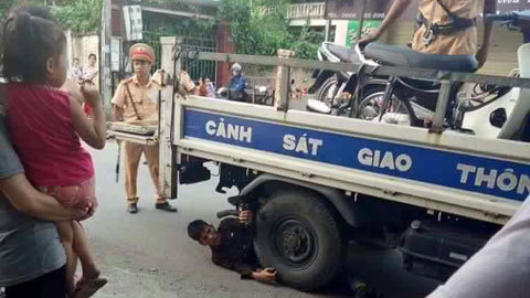 Ôm bánh xe ô tô Cảnh sát giao thông ăn vạ