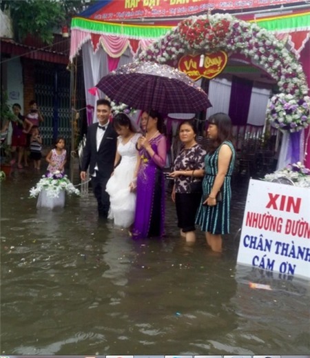 Cô dâu chú rể bì bõm lội nước tiếp khách giữa trời mưa dậy sóng mạng