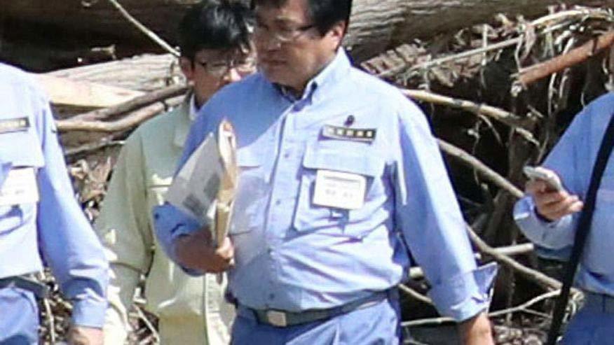 Quan chức Nhật để cấp dưới cõng qua vũng nước