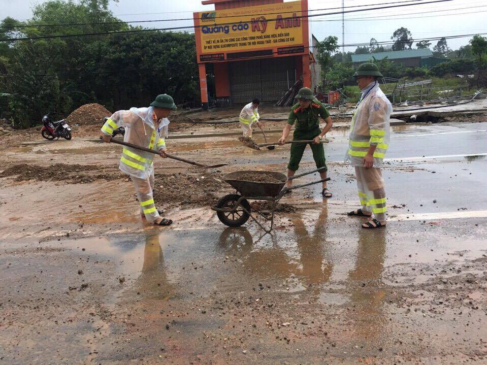 Cảnh sát đội mưa dọn đất đá ngổn ngang sau lũ