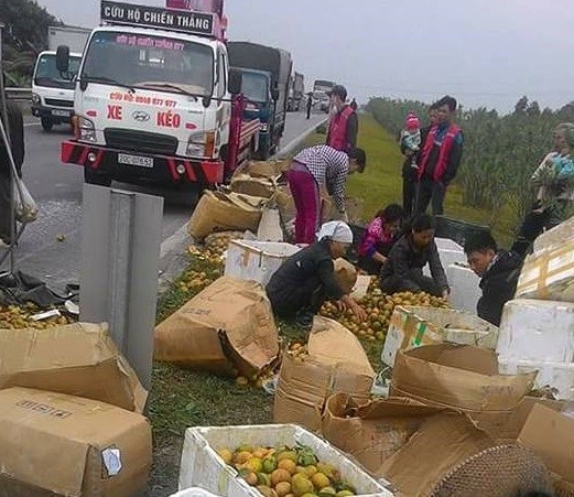 Xe tải bị lật, người dân thu gom hoa quả giúp tài xế