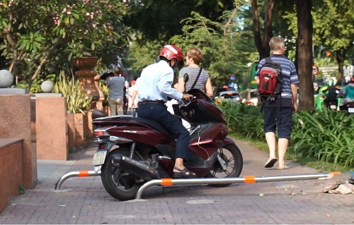 Người Sài Gòn lạng lách xe máy trên vỉa hè có barie chắn ngang