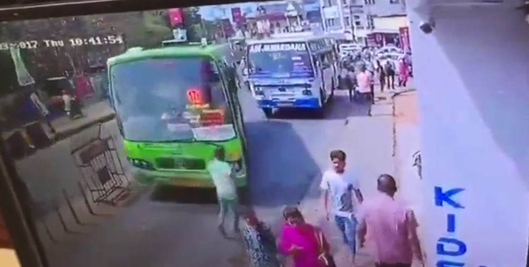 Mải xem điện thoại, bị xe buýt tông văng lên vỉa hè
