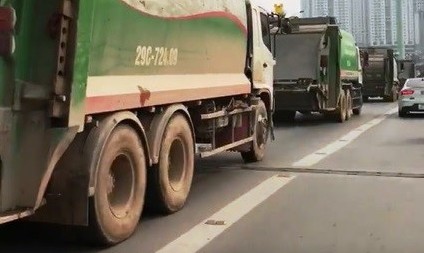 Xe chở rác nối đuôi nhau chạy vào làn buýt nhanh