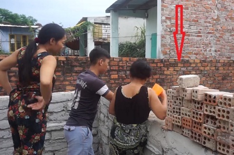 Người đàn ông chết dựa lưng vào tường, dây lưng quấn cổ