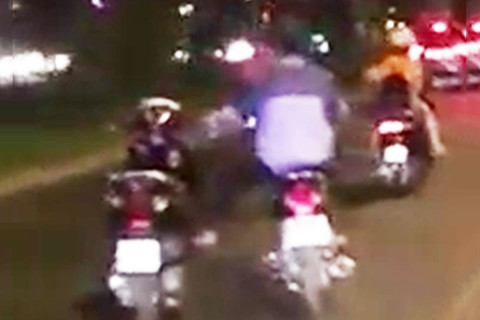 Thanh niên một mình lái hai xe máy trên đường