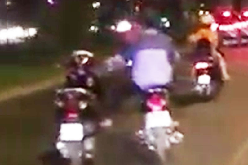 Thanh niên một mình lái hai xe máy trên đường