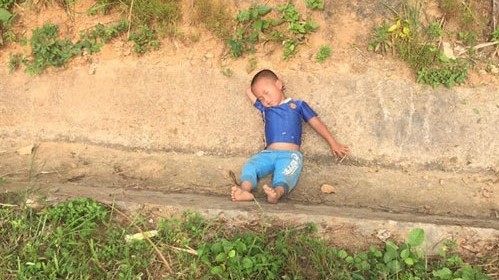 Bé trai đi xem tai nạn giao thông rồi ngủ quên luôn tại vệ đường