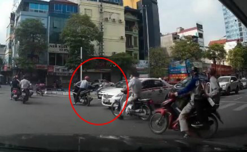 Đi xe máy vượt đèn đỏ, tạt đầu taxi còn cố tình gây sự