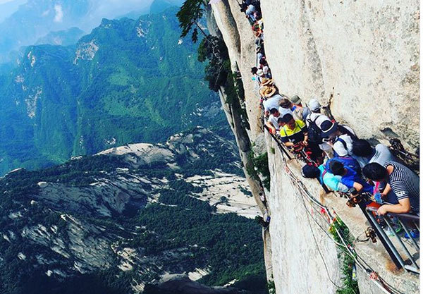Du khách chen chúc trên đường ván đính hờ vào vách đá