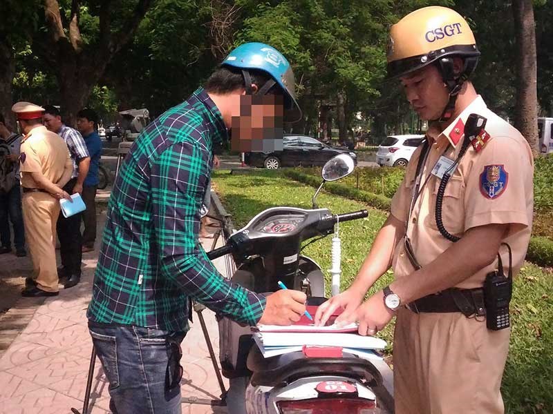 Dắt xe máy qua chốt CSGT, có bị phạt?