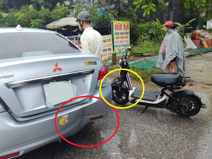 Vừa che ô vừa dùng điện thoại, lái xe đạp điện đâm vào đuôi ô tô