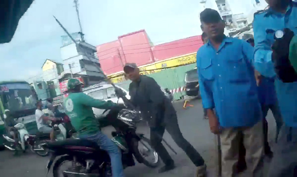 Nam thanh niên đối tác của GrabBike đứng trước cổng bến xe An Sương để chờ đón khách thì bị nhóm xe ôm truyền thống đến hăm dọa rồi đánh hội đồng gây thương tích…