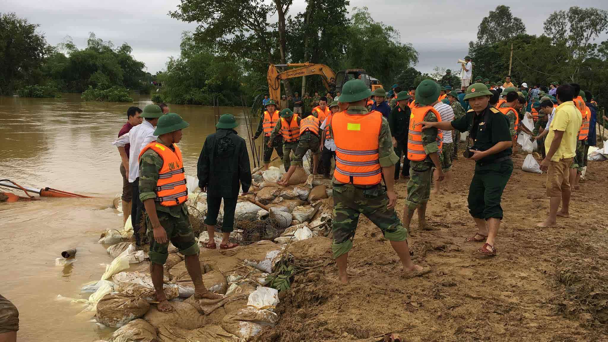 Lao máy xúc xuống sông cản dòng chảy, cứu đê sắp vỡ
