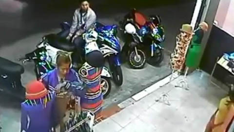 Cặp đôi móc ví trước cửa tiệm thời trang