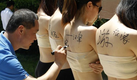 Mỹ nữ tình nguyện lưng trần cho du khách vẽ bậy