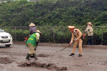 Hà Nội: CSGT quét đất đá rơi vãi trên đường