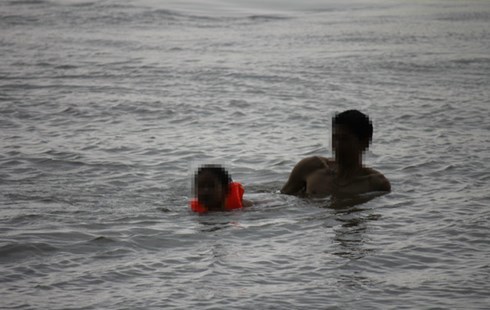 Trời mưa gió, sấm chớp phụ huynh vẫn đưa con đi tắm sông Hồng