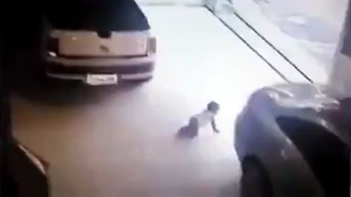 Lùi ô tô vào bé 1 tuổi bò dưới gầm