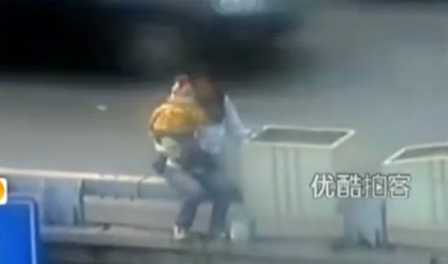 Người phụ nữ bồng con nhỏ định nhảy cầu