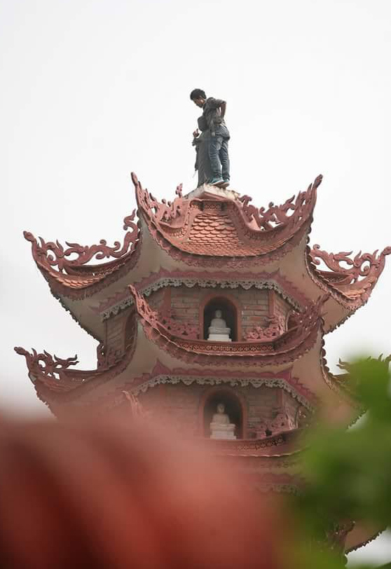 Hà Nội: Nam thanh niên leo lên tháp chùa quậy phá